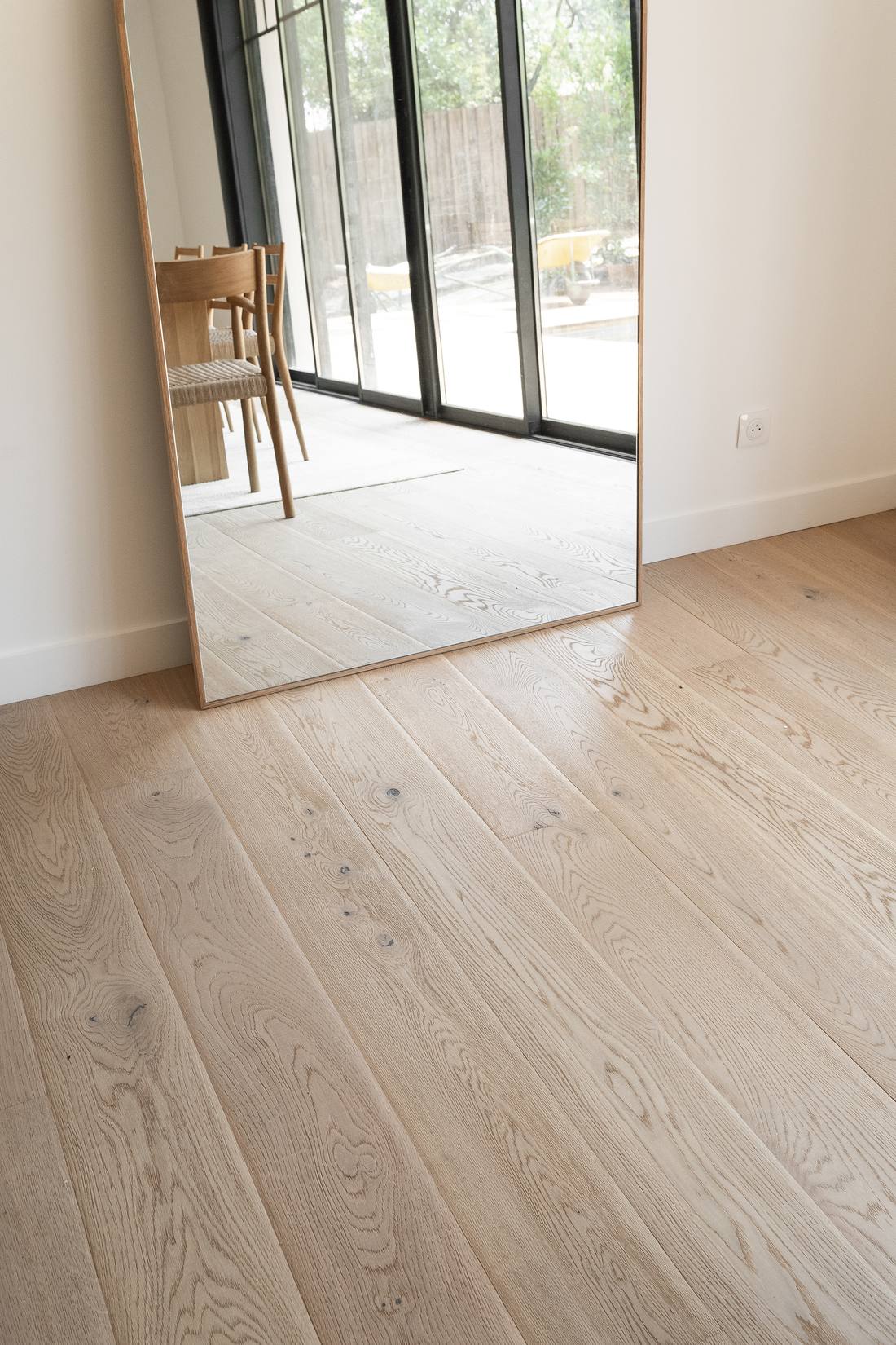 Détail d'un parquet en chêne massif et d'un grand miroir, finitions d'un artisan du Bassin d'Arcachon