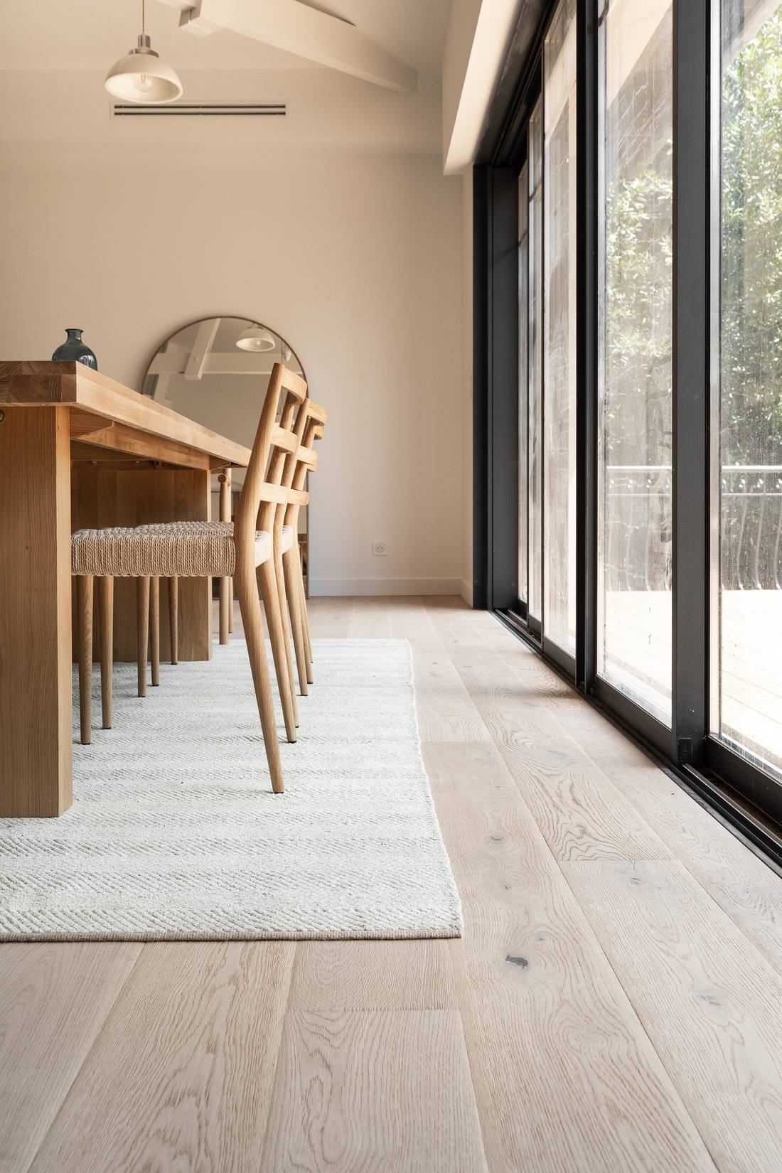 Salle à manger avec grande table en bois et baies vitrées à menuiseries noires, Bassin d'Arcachon