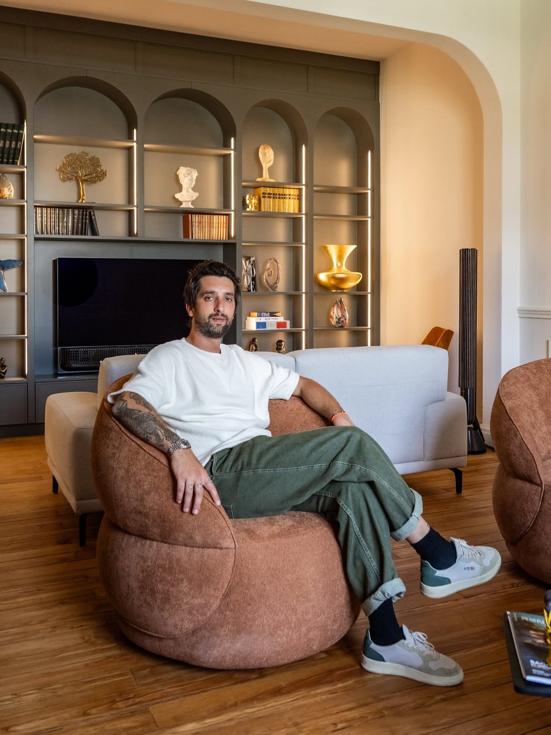 Salon avec bibliothèque à arches et fauteuils en cuir, portrait d'un client chez lui en Gironde