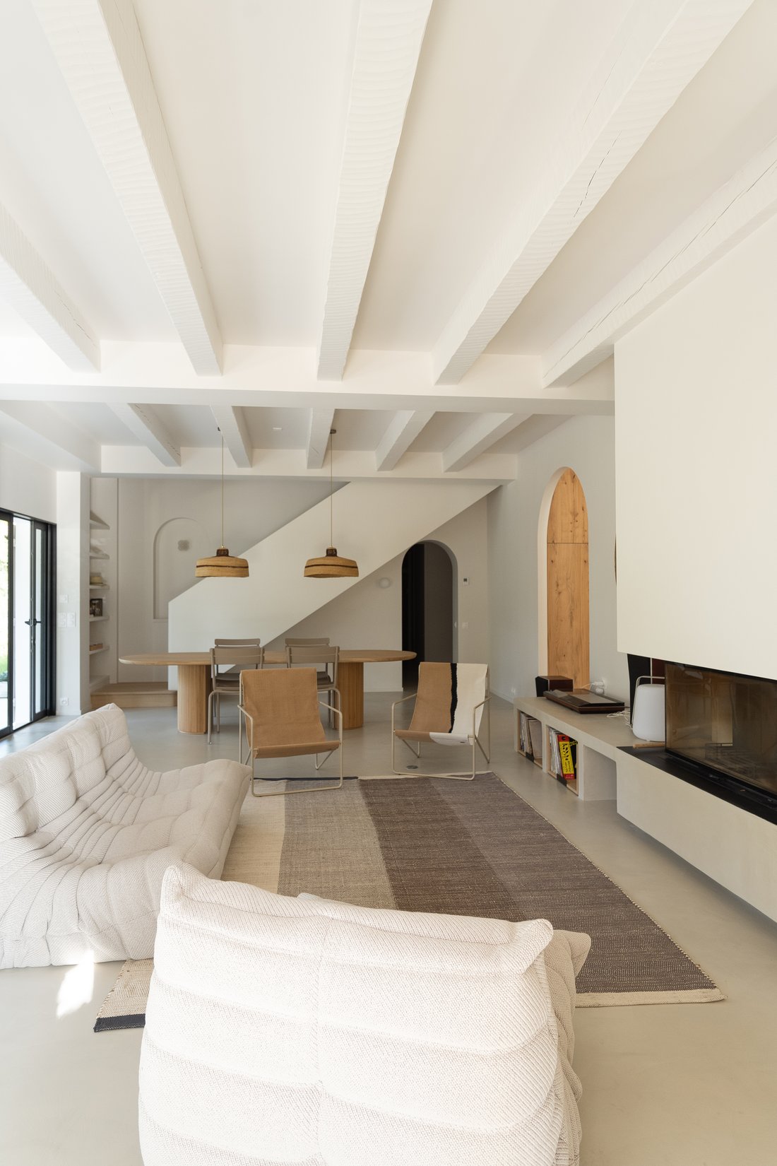Séjour sous poutres blanches avec niche en arche et cheminée encastrée, villa du Bassin d'Arcachon
